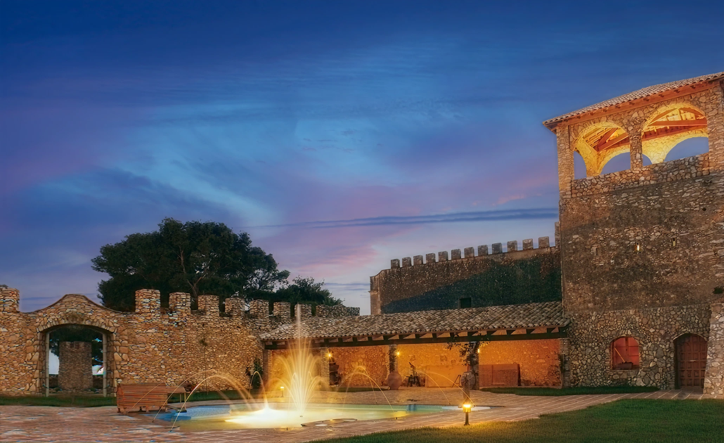  Bodegas Jaume Serra con muralla y fuente iluminada al atardecer